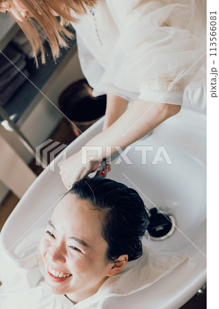 美容室でシャンプーをしてもらう若い女性 113566081