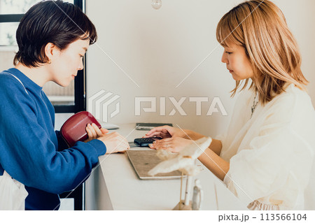 お会計をする若い女性と店員 113566104