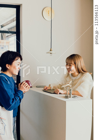 お会計をする若い女性と店員 お会計をする若い女性と店員 113566113