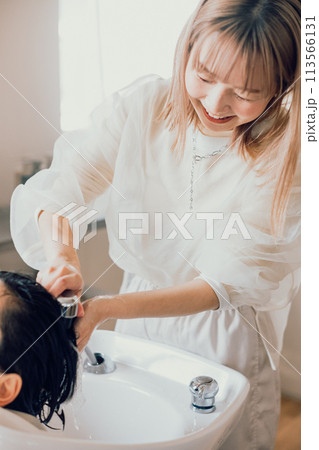 美容室でシャンプーをしてもらう若い女性 113566131