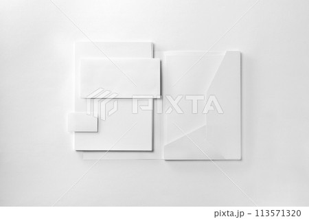 Corporate stationery set mockup. Presentation folder, envelope, letterheads stack and business card at white textured paper background. Corporate stationery set mockup. Presentation folder, envelope, letterheads stack and business card at white textured paper background. 113571320