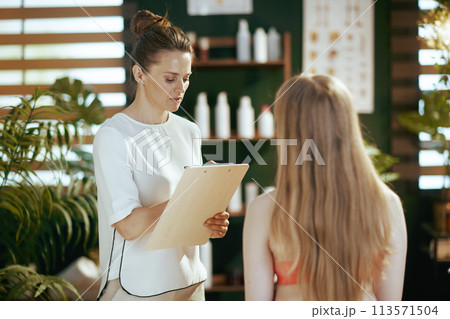 therapist woman in massage cabinet conducting examination therapist woman in massage cabinet conducting examination 113571504