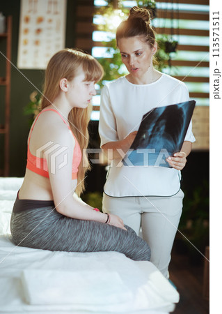 concerned female therapist in massage cabinet doing checkup 113571511
