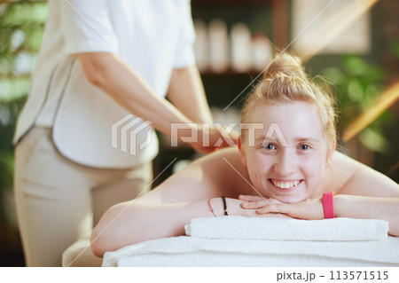 female therapist in massage cabinet making massage 113571515