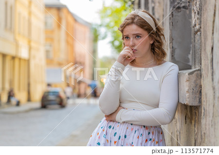 Sad unhappy frustrated young woman walking alone in city street feeling bad annoyed grief problem Sad unhappy frustrated young woman walking alone in city street feeling bad annoyed grief problem 113571774