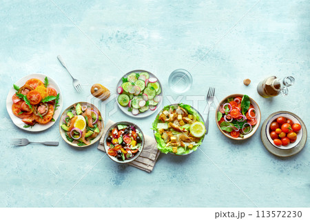 Fresh salads, overhead flat lay shot of an assortment. Variety of plates Fresh salads, overhead flat lay shot of an assortment. Variety of plates 113572230