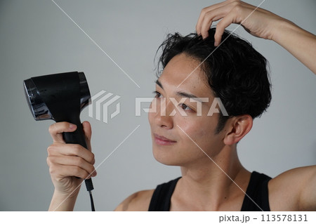 ヘアセットをする若い男性 ヘアセットをする若い男性 113578131