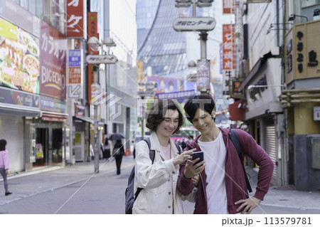 インバウンド 渋谷の街をスマホを見ながら観光する外国人カップル インバウンド 渋谷の街をスマホを見ながら観光する外国人カップル 113579781