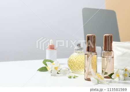 Jasmine flowers and perfume bottles on gray background 113581569