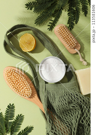 Eco bag, brushes, leaves, lemon and soda in bowl on green background, top view Eco bag, brushes, leaves, lemon and soda in bowl on green background, top view 113581606