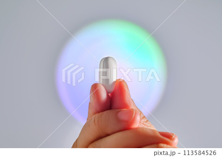 Tablet in hand against the background of a glowing circle. Tablet in hand against the background of a glowing circle. 113584526
