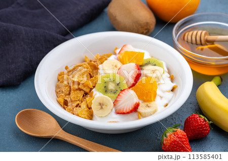 食卓に置かれた朝食のシリアルにヨーグルトとフルーツ 113585401