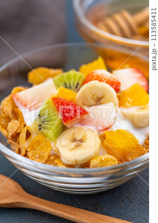 食卓に置かれた朝食のシリアルにヨーグルトとフルーツ 食卓に置かれた朝食のシリアルにヨーグルトとフルーツ 113585411