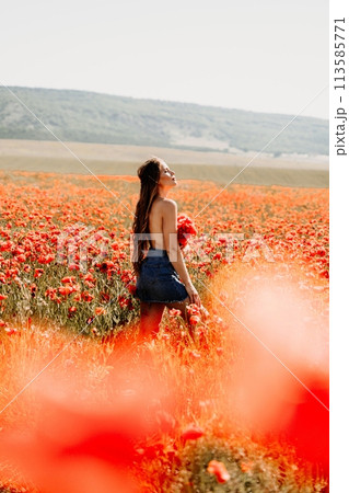 Woman poppies field. portrait happy woman with long hair in a poppy field and enjoying the beauty of nature in a warm summer day. 113585771