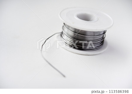 Tin-lead solder in coils on a white background. Materials for soldering. Tin-lead solder in coils on a white background. Materials for soldering. 113586398
