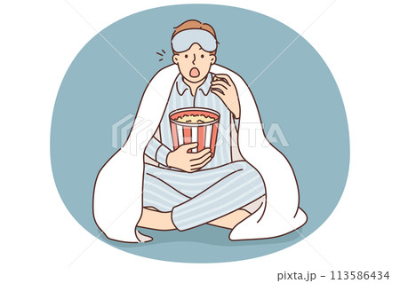 Man in pajama eat popcorn watch movie 113586434