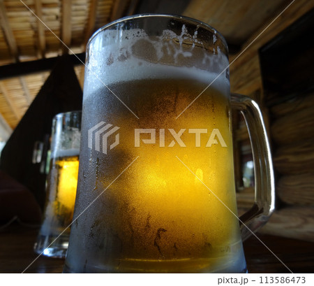 Two pints of craft beer with froth on the glass on the wood table Two pints of craft beer with froth on the glass on the wood table 113586473