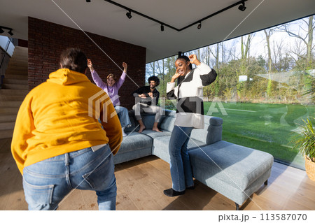 Joyful Friends Dancing Together in a Bright Modern Living Room Joyful Friends Dancing Together in a Bright Modern Living Room 113587070
