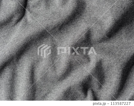 Gray cotton fabric texture. Clothes cotton jersey background with folds Gray cotton fabric texture. Clothes cotton jersey background with folds 113587227