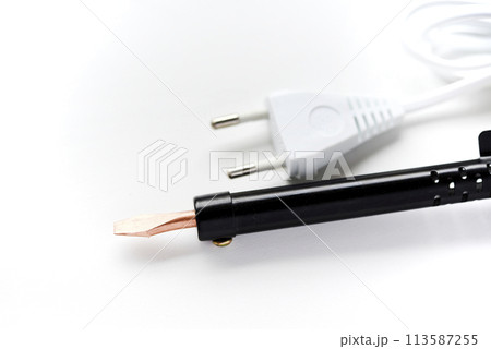 Electric soldering iron with a wooden handle on a white background. A tool for soldering radio components. Electric soldering iron with a wooden handle on a white background. A tool for soldering radio components. 113587255