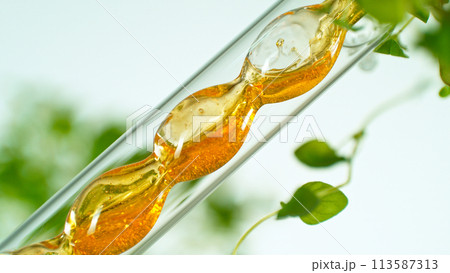 Getting essential oil from natural substances and flowers. Yellow oil flows in a spiral. 113587313