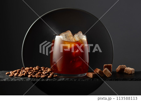Black coffee with ice on a black background. 113588113