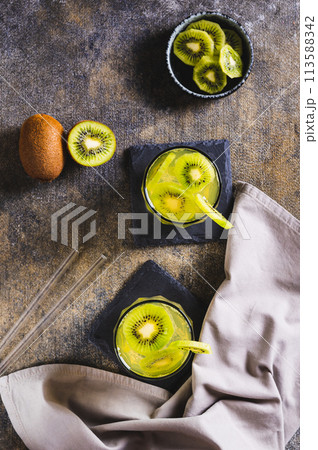 Refreshing tropical drink mojito with kiwi in glasses on the table top and vertical view 113588342