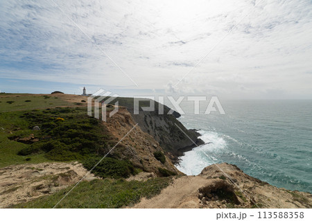 A beautiful view of the ocean with a lighthouse in the distance 113588358