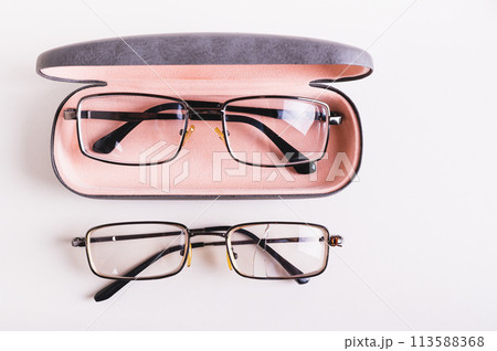 Whole glasses in a hard case and broken glasses on the table top view 113588368