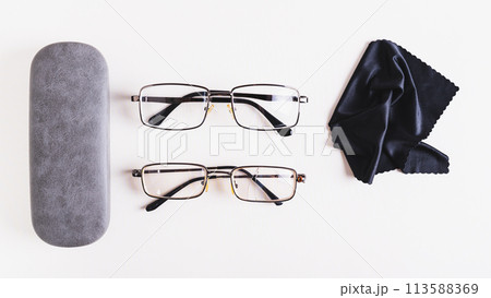 Whole glasses, broken glasses, hard case and cleaning cloth on table top view web banner Whole glasses, broken glasses, hard case and cleaning cloth on table top view web banner 113588369