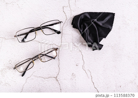 Whole glasses, broken glasses and cleaning cloth on a gray background top view 113588370
