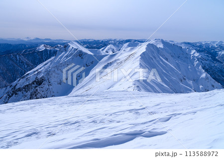 雪の谷川岳・山頂付近より望む稜線の山並み（ぐんま県境稜線トレイル） 113588972