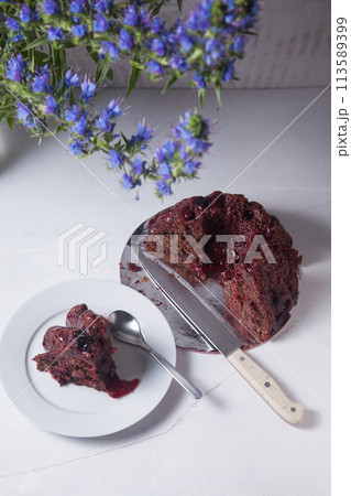 Chocolate cake, vintage kettle and bouquet of blue flowers on white background.. Chocolate cake, vintage kettle and bouquet of blue flowers on white background.. 113589399