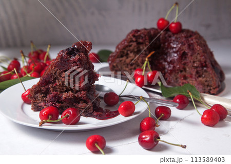 Chocolate cake with sweet cherry, cup of tea and bouquet of blue flowers on white background.. 113589403