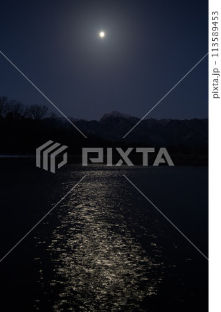 月齢18.2西に傾く寝待月、灌漑用水池の水面に映る月の道 113589453