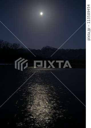 月齢18.2西に傾く寝待月、灌漑用水池の水面に映る月の道 113589454