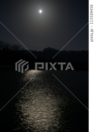 月齢18.2西に傾く寝待月、灌漑用水池の水面に映る月の道 113589456