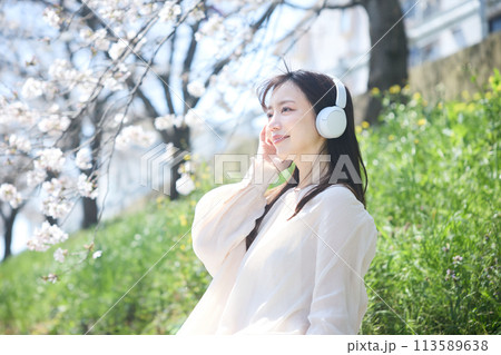桜の下で音楽を聴く女性 113589638