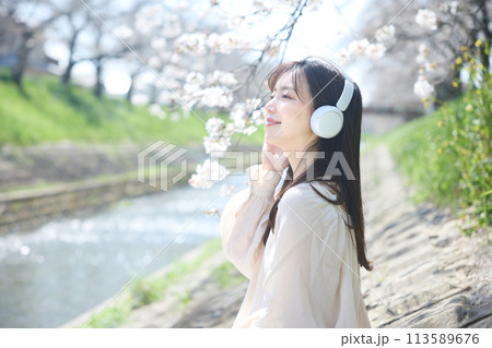 桜の下で音楽を聴く女性 113589676