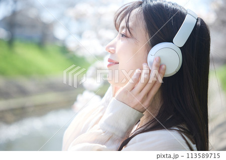 桜の下で音楽を聴く女性 113589715