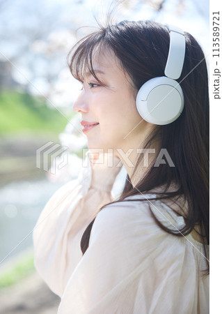 桜の下で音楽を聴く女性 113589721