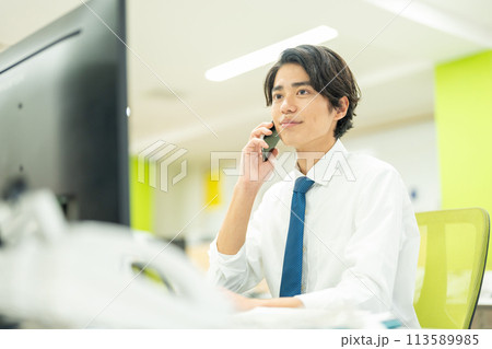 オフィスで電話する若いビジネスマン 113589985