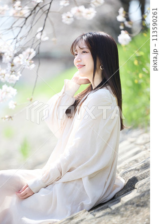 桜の下で花見をする女性 113590261