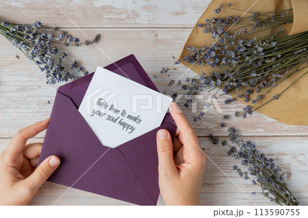 TAKE TIME TO MAKE YOUR SOUL HAPPY text on supportive message paper note reminder from green envelope. Flat lay composition dry lavender flowers. Concept of inner happiness, slowing-down digital detox TAKE TIME TO MAKE YOUR SOUL HAPPY text on supportive message paper note reminder from green envelope. Flat lay composition dry lavender flowers. Concept of inner happiness, slowing-down digital detox 113590755