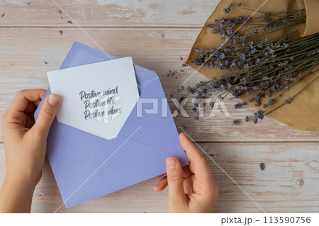 POSITIVE MIND LIFE VIBES text on supportive message paper note reminder from violet envelope. Flat lay composition dry lavender flowers. Concept of inner happiness, slowing-down digital detox personal 113590756