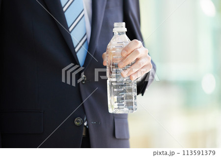 ビジネスイメージ  ペットボトルを持つスーツ姿の若い男性　 113591379
