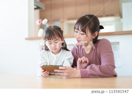 スマートフォンを使う親子 女の子とお母さん スマートフォンを使う親子 女の子とお母さん 113591547