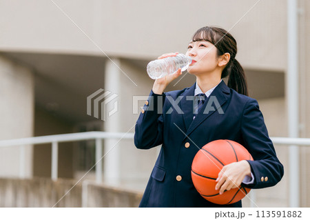 校舎の前でバスケットボールを持つ女子中学生・女子高生（部活・スポーツ・運動部・バスケ部） 113591882