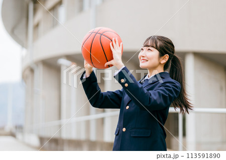 校舎の前でバスケットボールを持つ女子中学生・女子高生（部活・スポーツ・運動部・バスケ部） 113591890