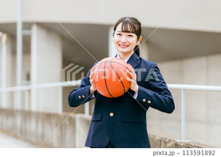 校舎の前でバスケットボールを持つ女子中学生・女子高生（部活・スポーツ・運動部・バスケ部） 113591892
